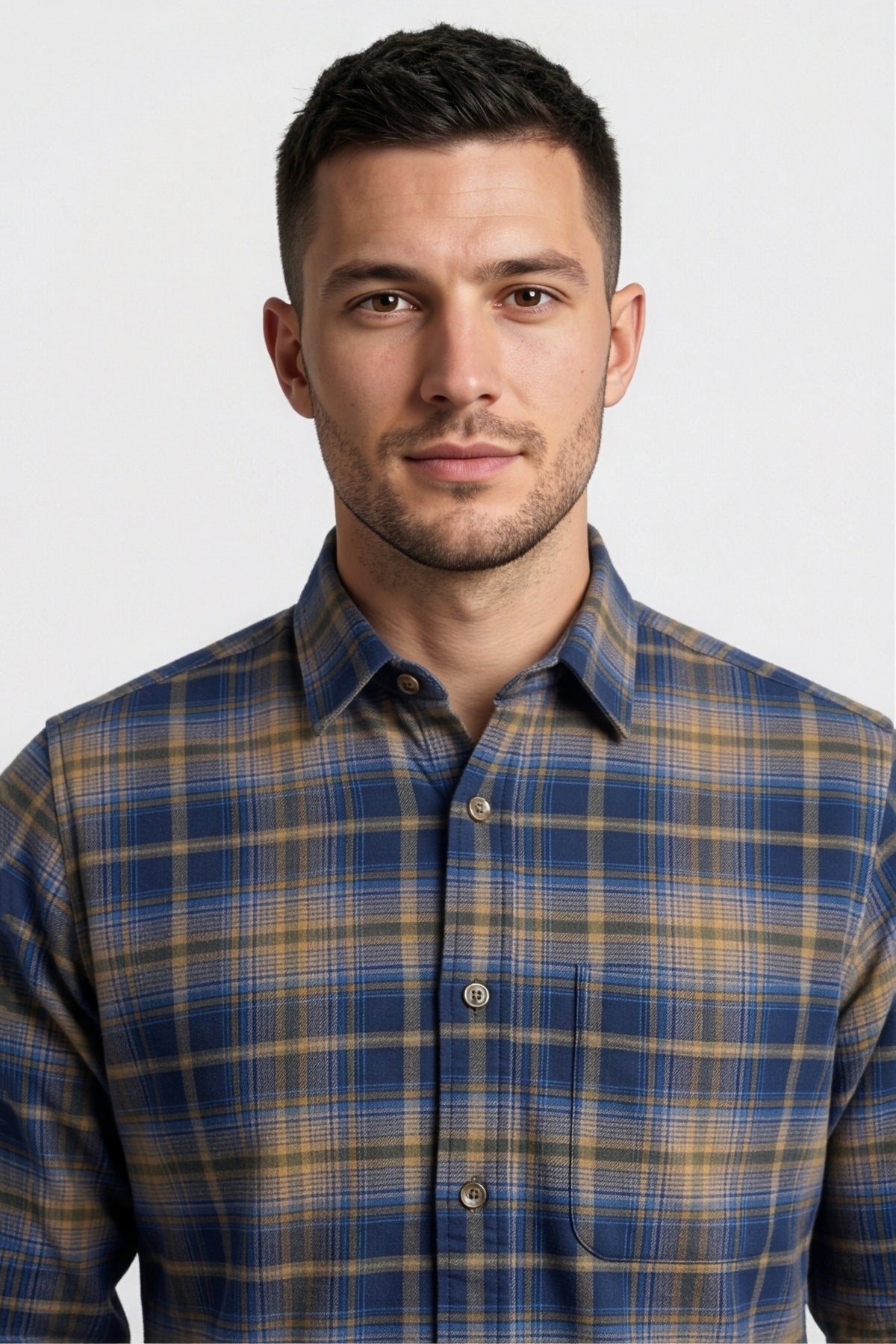 Collar and chest pocket detail of navy and tan plaid flannel shirt