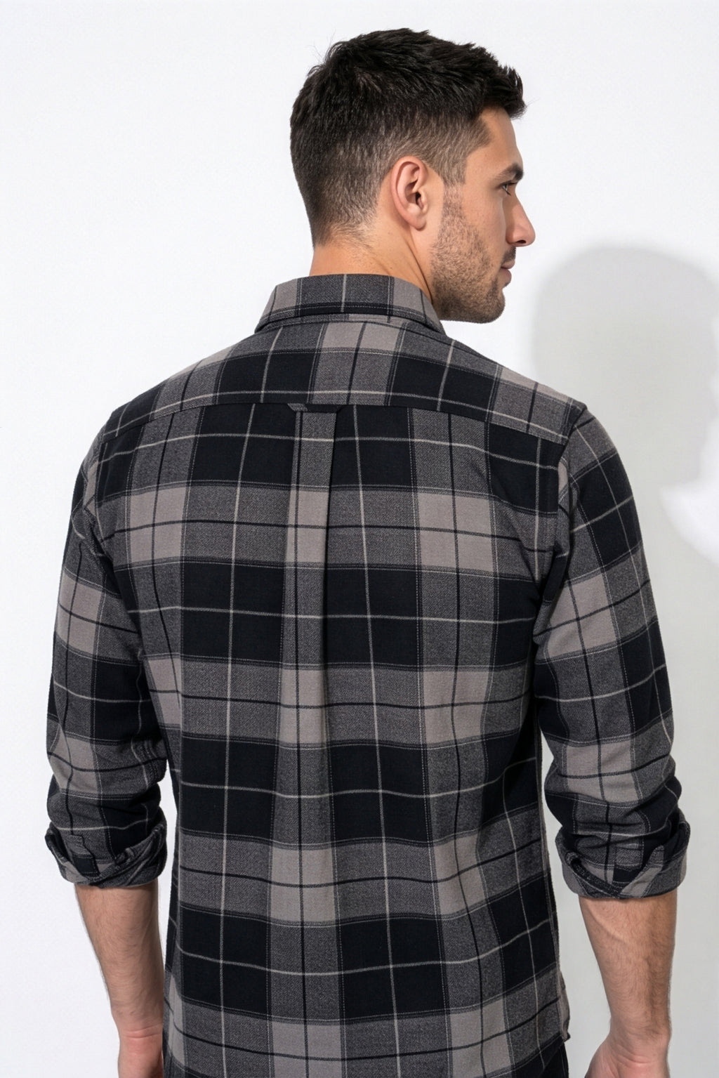 Back yoke and centre pleat detail of black and grey plaid flannel shirt