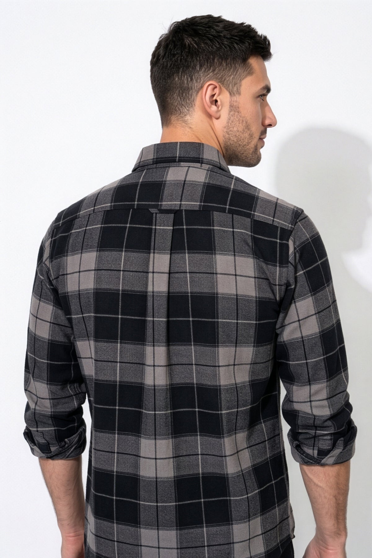 Back yoke and centre pleat detail of black and grey plaid flannel shirt
