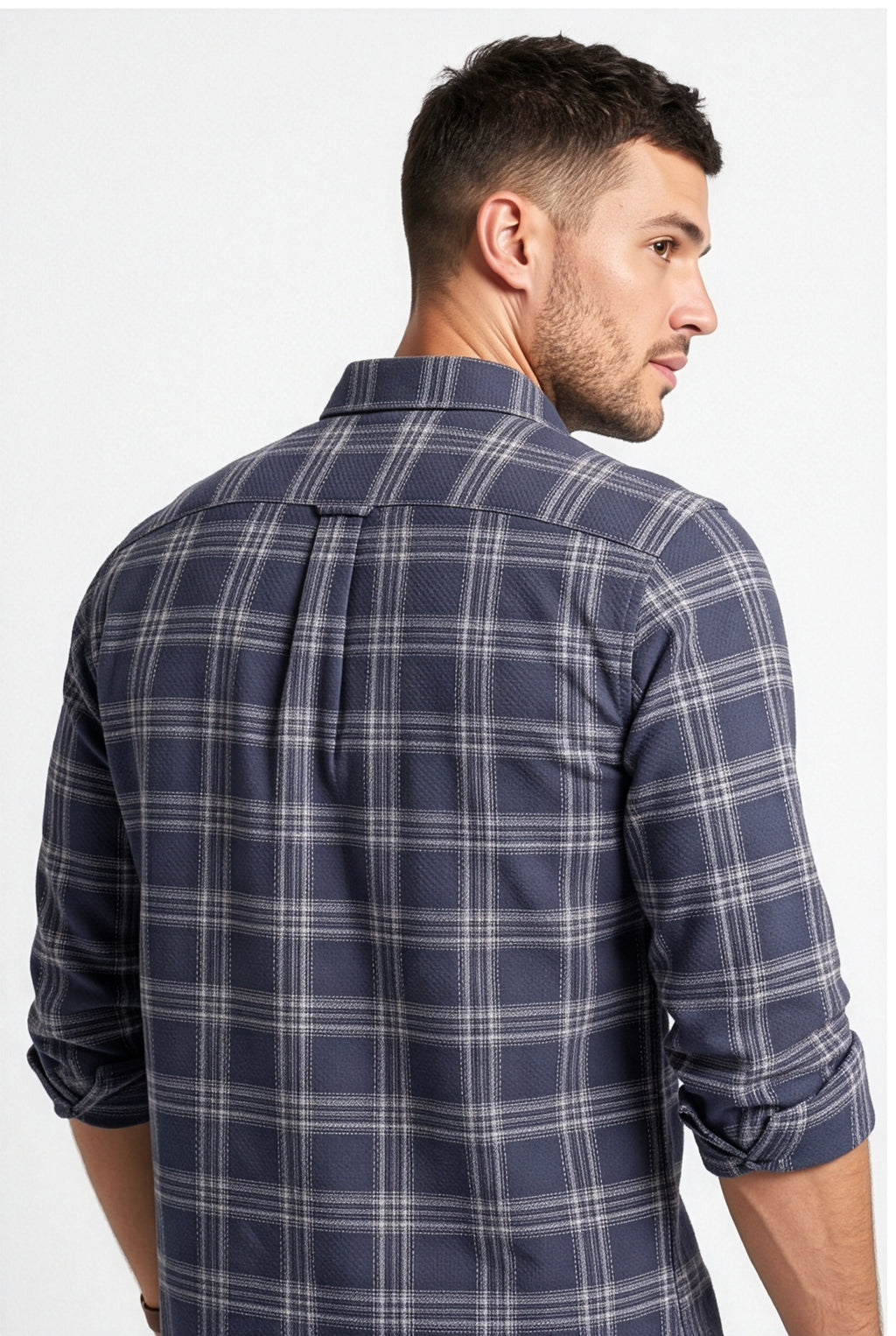 Back yoke and centre pleat detail of navy and grey plaid cotton dobby shirt