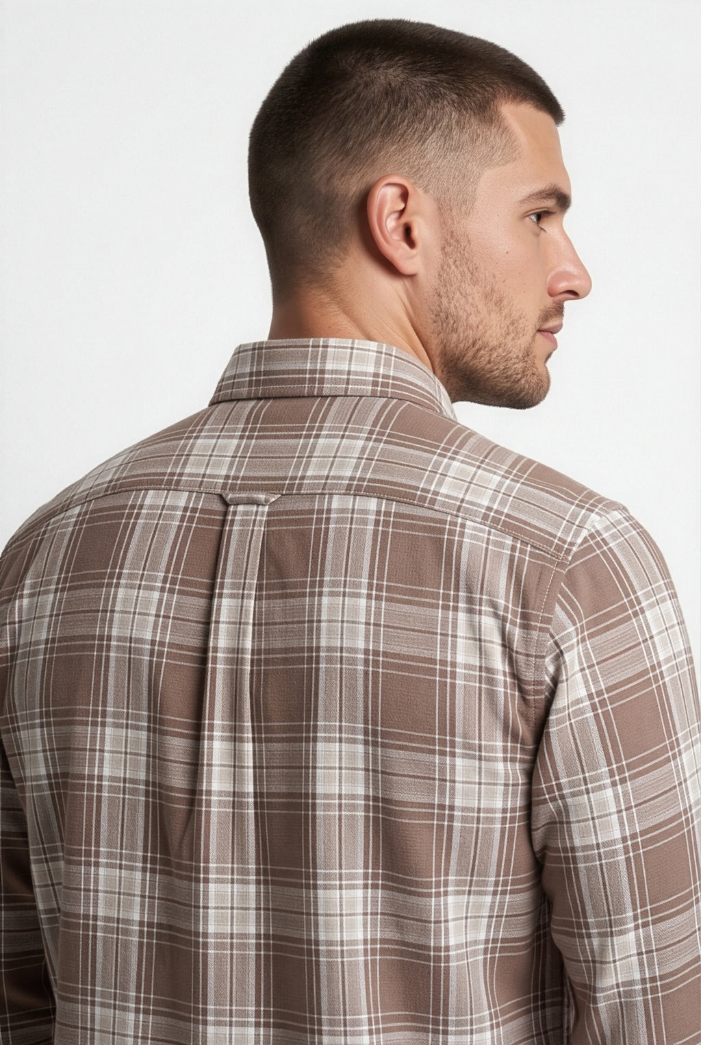 Back yoke and centre pleat detail of brown and cream plaid cotton dobby shirt